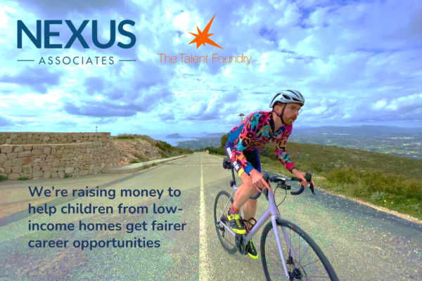 A cyclist in colorful attire riding uphill on a road with cloudy skies and distant mountain scenery, alongside logos and a social cause message.